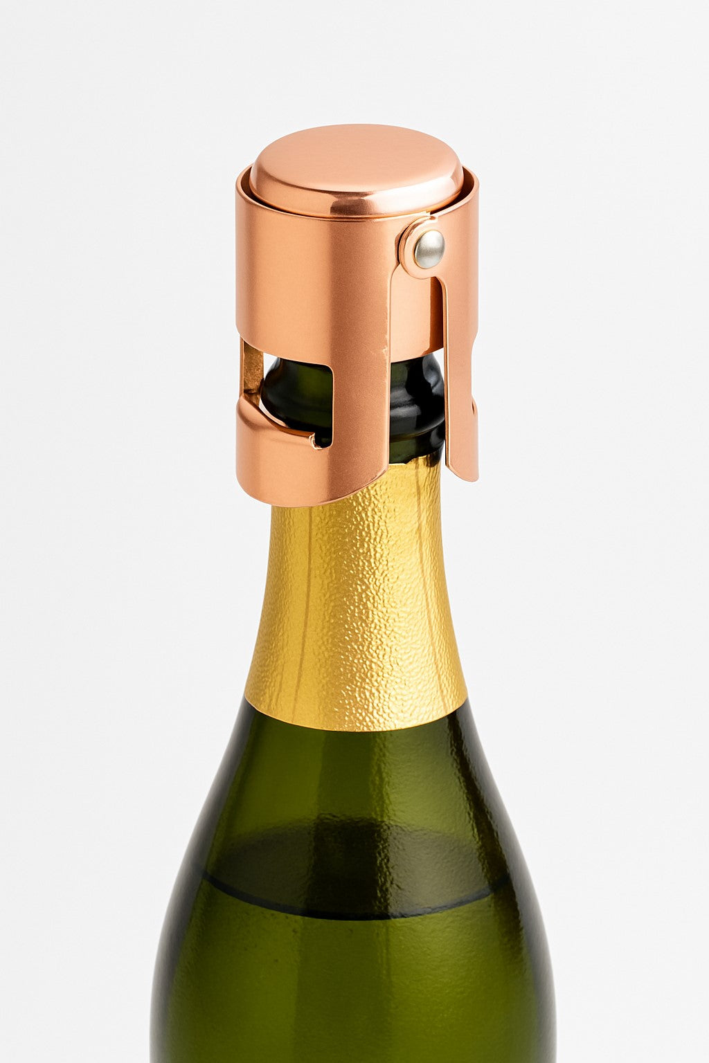 A rose gold champagne cork stopper fitted on a champagne bottle.