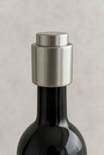 Load image into Gallery viewer, A close-up image of a silver stainless steel wine bottle stopper placed on top of a wine bottle, illustrating the product&#39;s use.